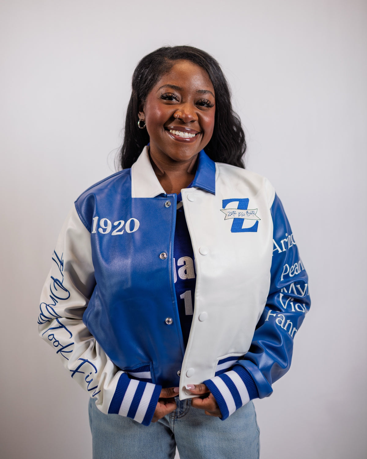 Model in the 5 For the Founders Leather Jacket, waist up: Royal Blue and white split front, split shirt collar, 1920 and the Zeta Phi Beta Z on the chest