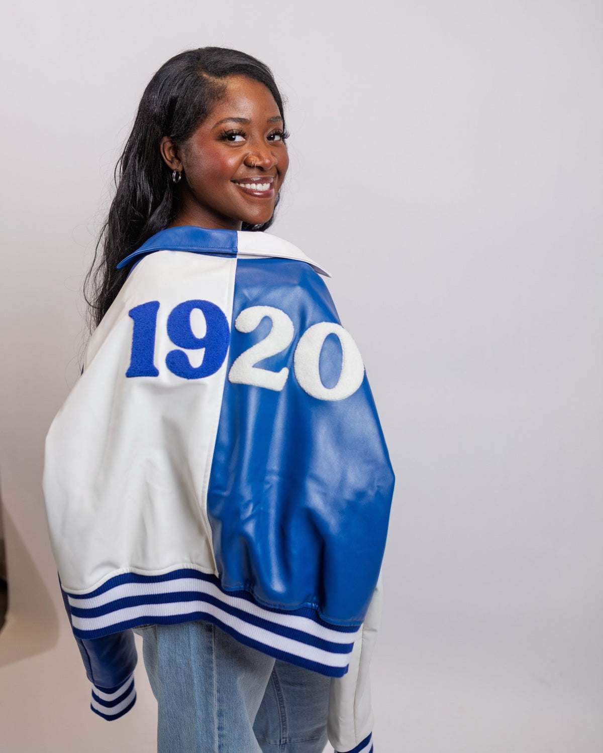 Model looking over her shoulder, showing 1920 split in Royal Blue and white chenille across the back