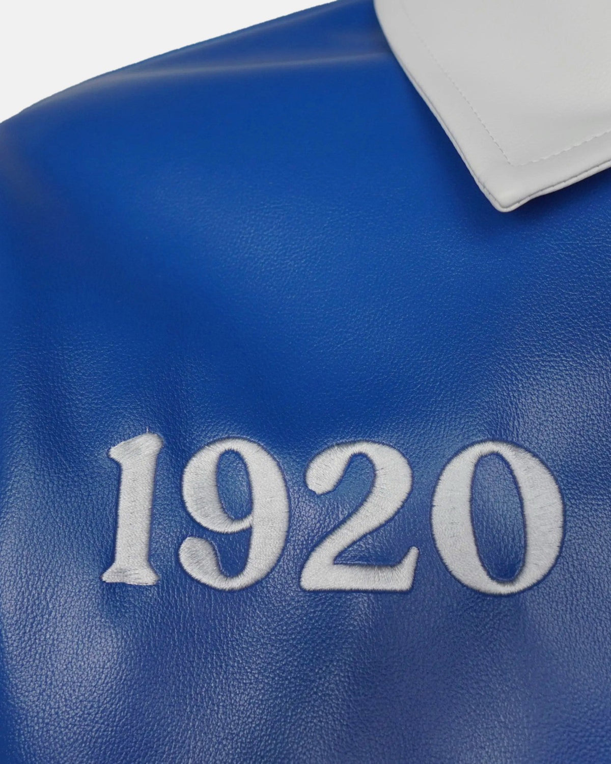 Detail: 1920 embroidered in white on the Royal Blue leather chest panel, below the split collar