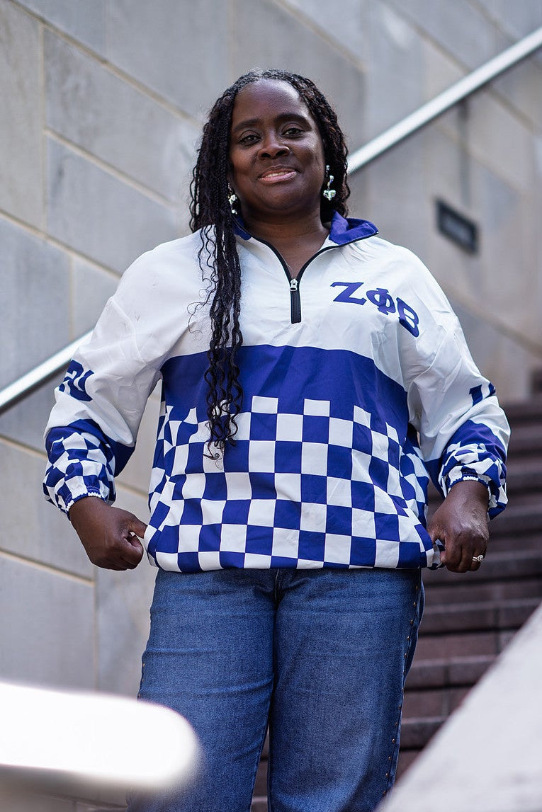 Zeta Phi Beta checkered windbreaker worn on campus steps